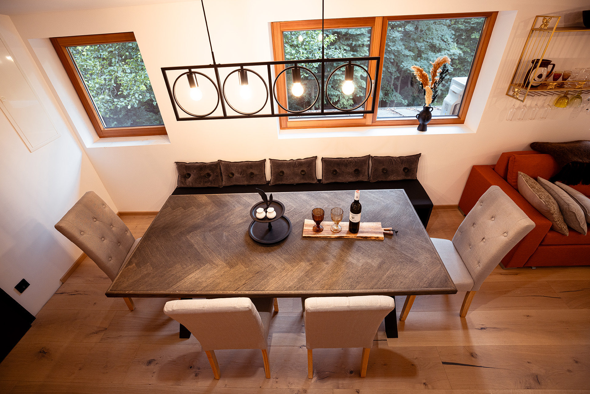 Wohn- und Essbereich der Wohnung Fuchs mit orangefarbenem Sofa