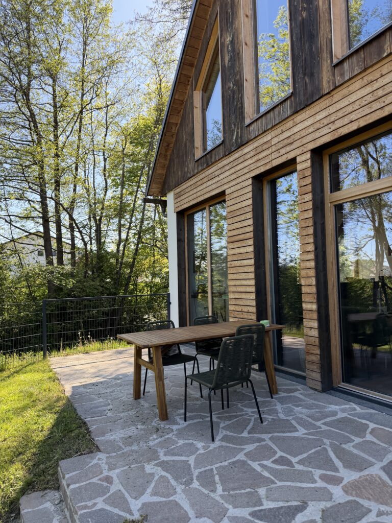 Terrasse mit Holzhaus-Fassade und Sitzgruppe im Garten von Johann & Anna